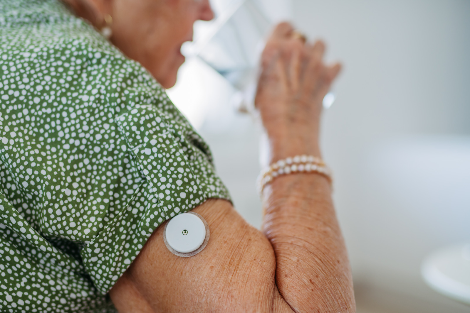 Elderly Woman Using CGM On Arm